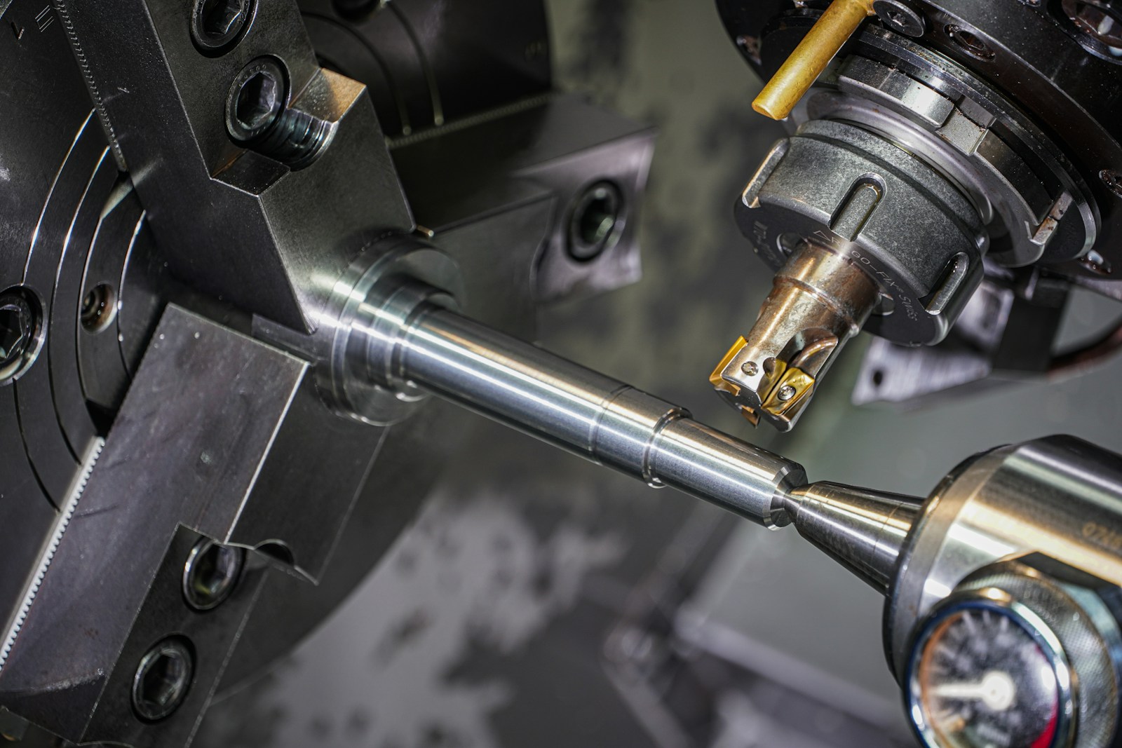 A metal shaft being machined on a lathe